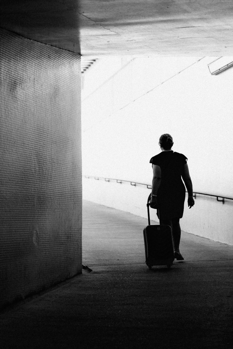 a man with a suitcase walking down a sidewalk